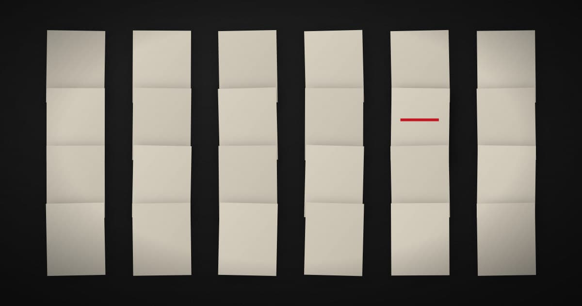 Many near-identical pale paper sheets fanned across a dark surface, with one sheet carrying a crimson mark the others do not have